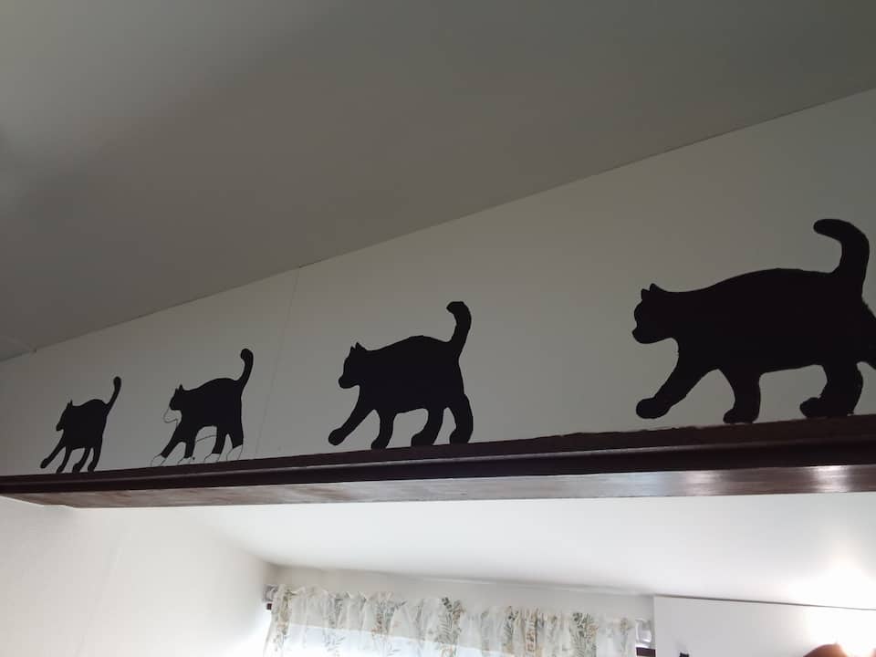 梁を歩く黒猫のシルエット